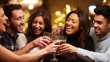 a group of young friends clinking glasses