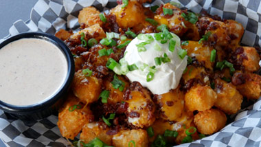 loaded tater tots with sour cream, chives, bacon and cheese